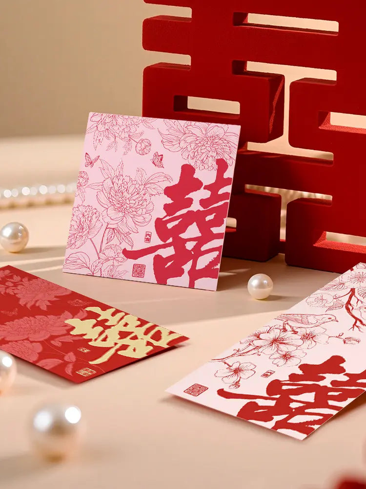 Red and gold Double Happinese Chinese Wedding Red Envelopes With Flowers and Birds on a beige surface with decorative elements.