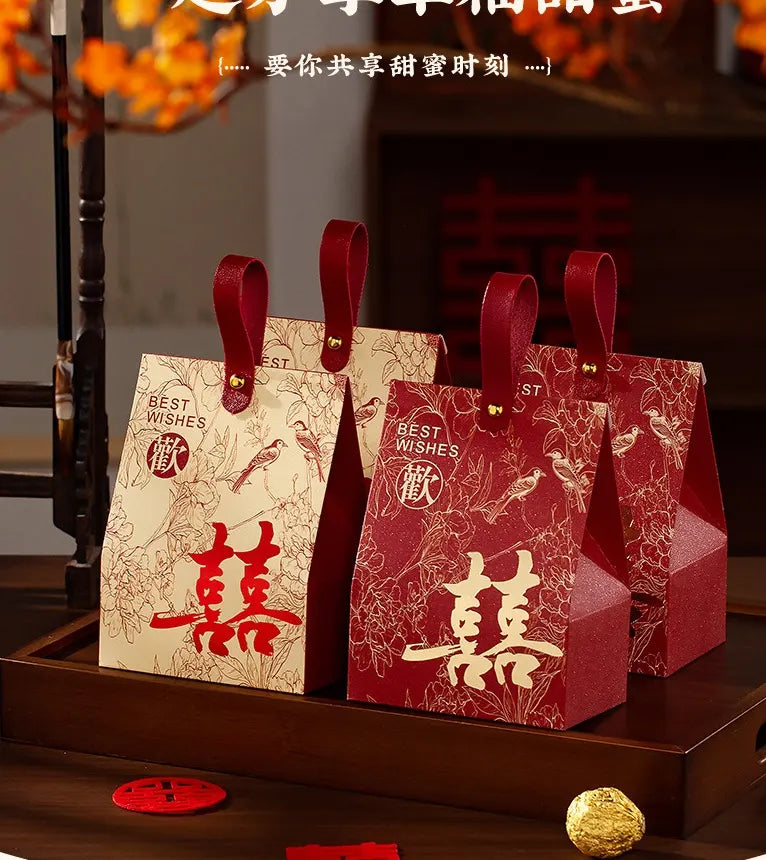 Three red  Double Happiness Chinese Wedding Favor Box with gold accents on a wooden surface.