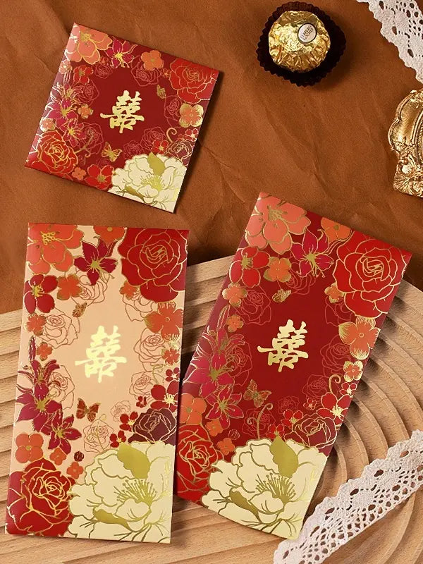 Three Double Happiness  Floral Wedding Red Envelopes  with gold text on a textured surface.