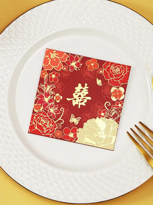 Double Happiness  Floral Wedding Red Envelopes  with gold floral patterns and Chinese characters on a white plate with a gold rim.