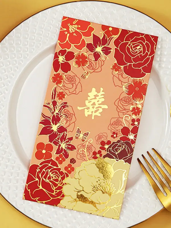 Double Happiness  Floral Wedding Red Envelopes  with floral patterns and gold text on a white plate with a gold fork.
