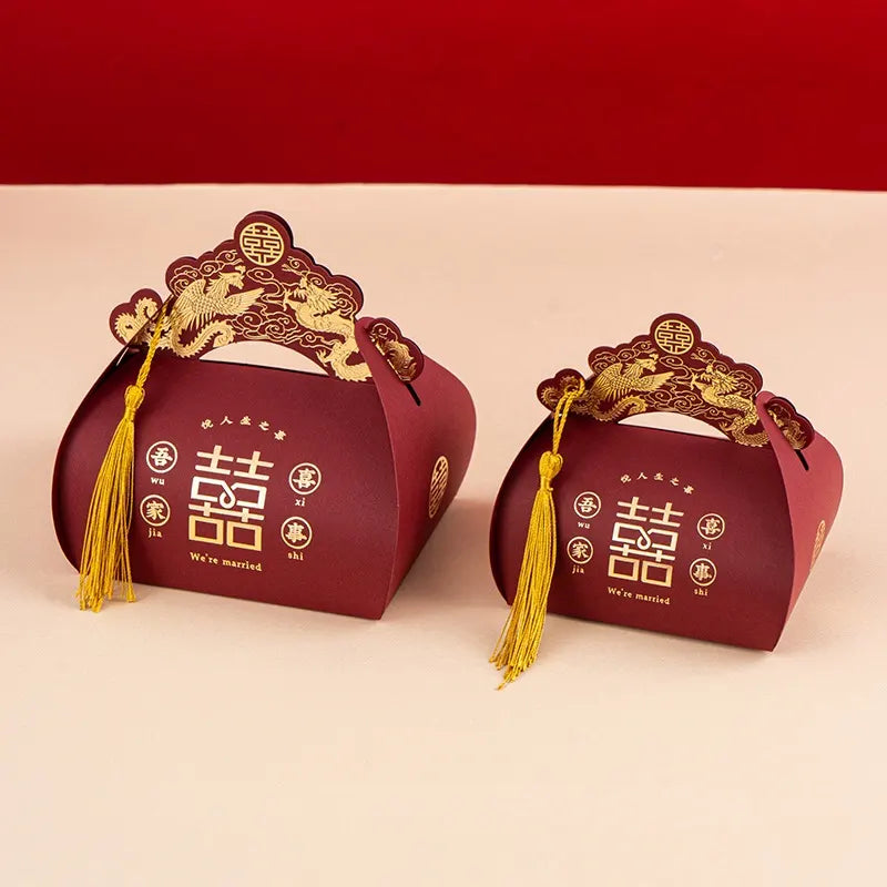 Two red Dragon & Phoenix Double Happiness Chinese Wedding Favor  gift boxes with gold designs and tassels on a beige background