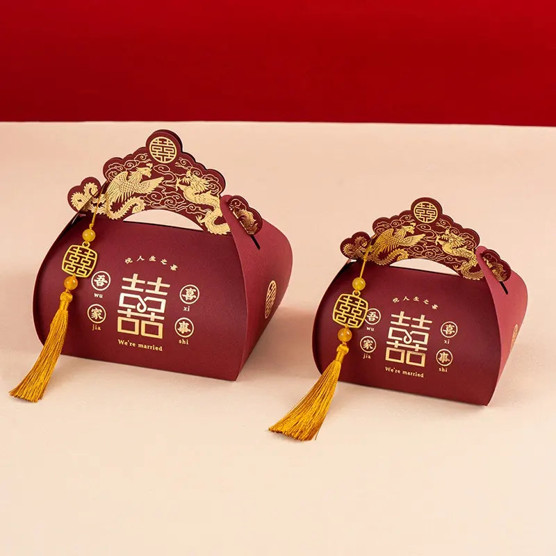 Two red Dragon & Phoenix Double Happiness Chinese Wedding Favor Boxes  with gold designs and tassels on a red background