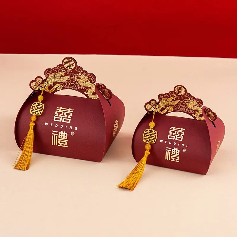 Two red Dragon & Phoenix Double Happiness Chinese Wedding Favor  gift boxes with gold accents and tassels on a red background.
