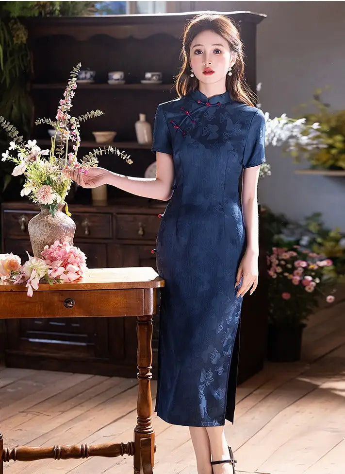 Woman in a Elegant Blue Jacquard Butterfly Cheongsam – Mid-Length Modern Qipao standing in a room with flowers and furniture.