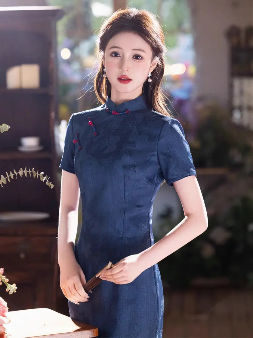 Woman wearing a Elegant Blue Jacquard Butterfly Cheongsam – Mid-Length Modern Qipao with a blurred indoor background