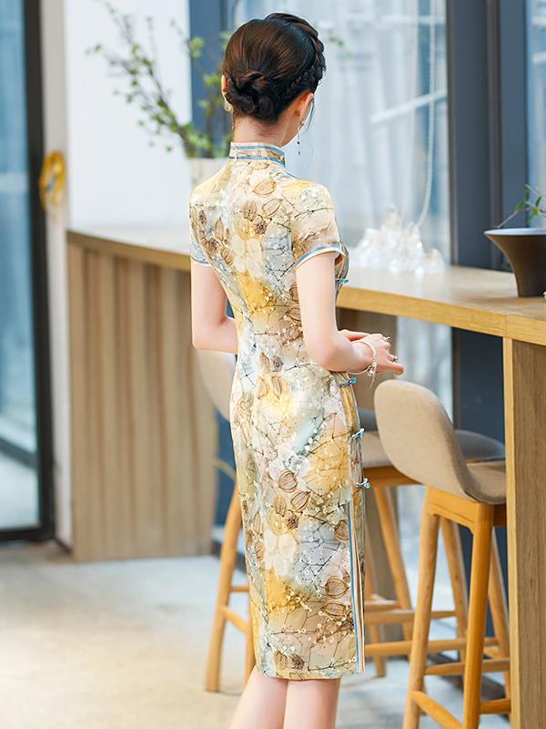 Woman in a Elegant Floral Mulberry Silk Qipao Cheongsam Dress  standing in a modern interior setting with wooden furniture and plants.