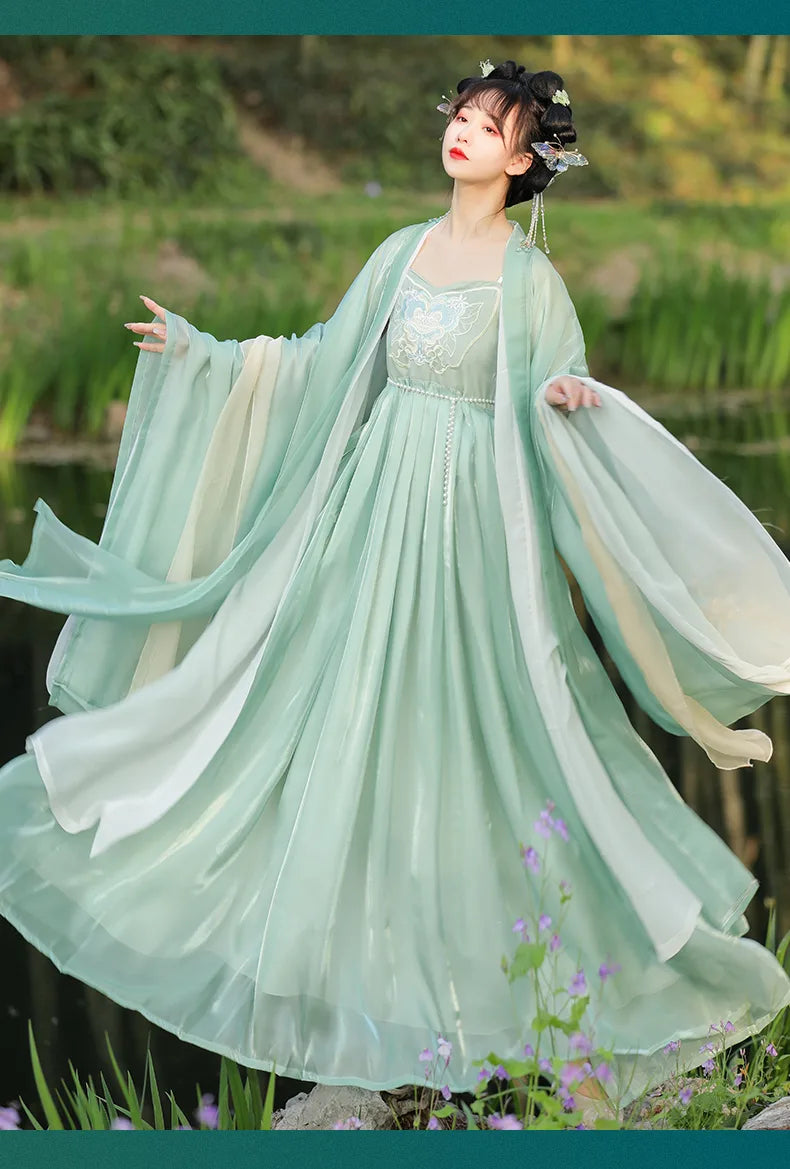Woman in a light green traditional Elegant Green Tang Dynasty Hanfu Dress standing in a natural setting with greenery.