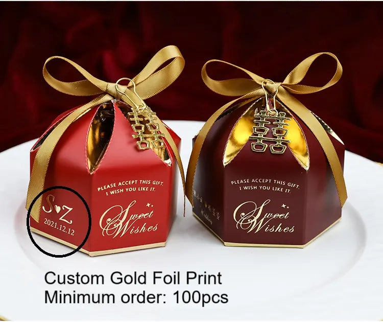 Two decorative chinese Wedding Favor Boxes with Double Happiness Charm with gold ribbons and custom gold foil print on a white surface.