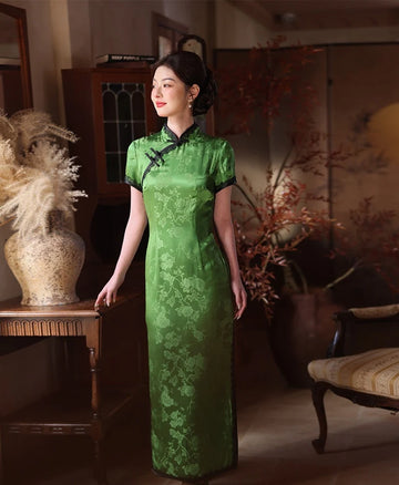 Woman in a Emerald Forest Green Silk-Blend Qipao with Lace Trim dress standing in an elegant room with decorative elements.