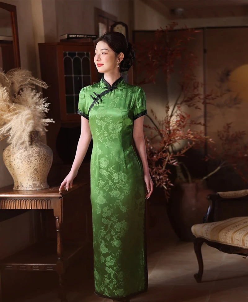 Woman in a Emerald Forest Green Silk-Blend Qipao with Lace Trim dress standing in an elegant room with decorative elements.