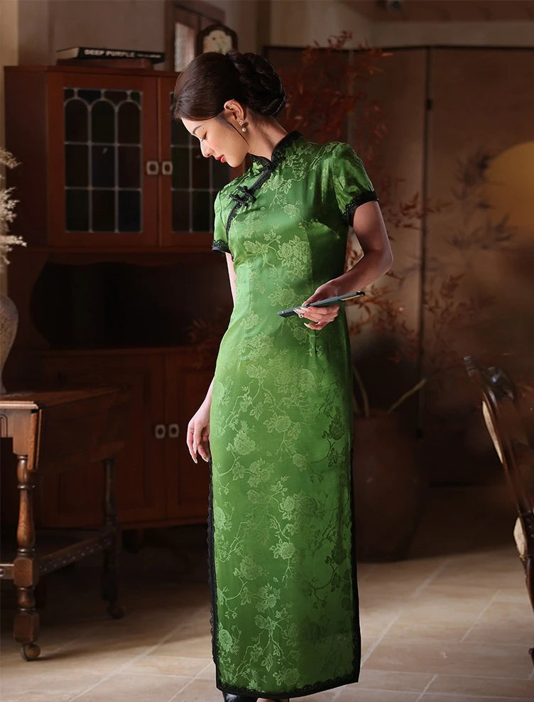 Woman in a Emerald Forest Green Silk-Blend Qipao cheongsam traditional dress  with Lace Trim  standing in a room with wooden furniture.