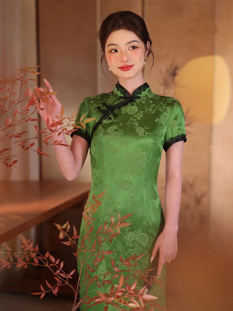 Woman in a Emerald Forest Green Silk-Blend Qipao with Lace Trim  dress holding leaves indoors