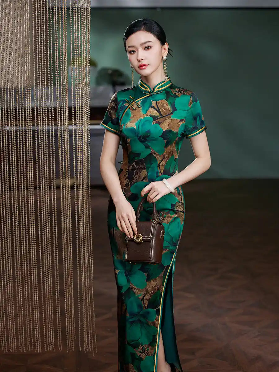 Woman in a Emerald Green Floral Silk Chinese Qipao Cheongsam Dress   holding a brown handbag indoors.