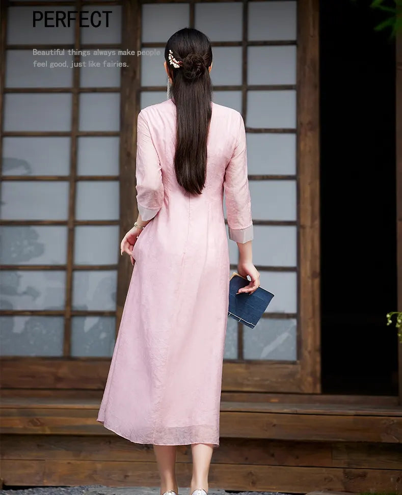 Woman in a Floral Embroidered Loose A line pink Cheongsam Qipao Dress standing in front of a wooden door with glass panels.