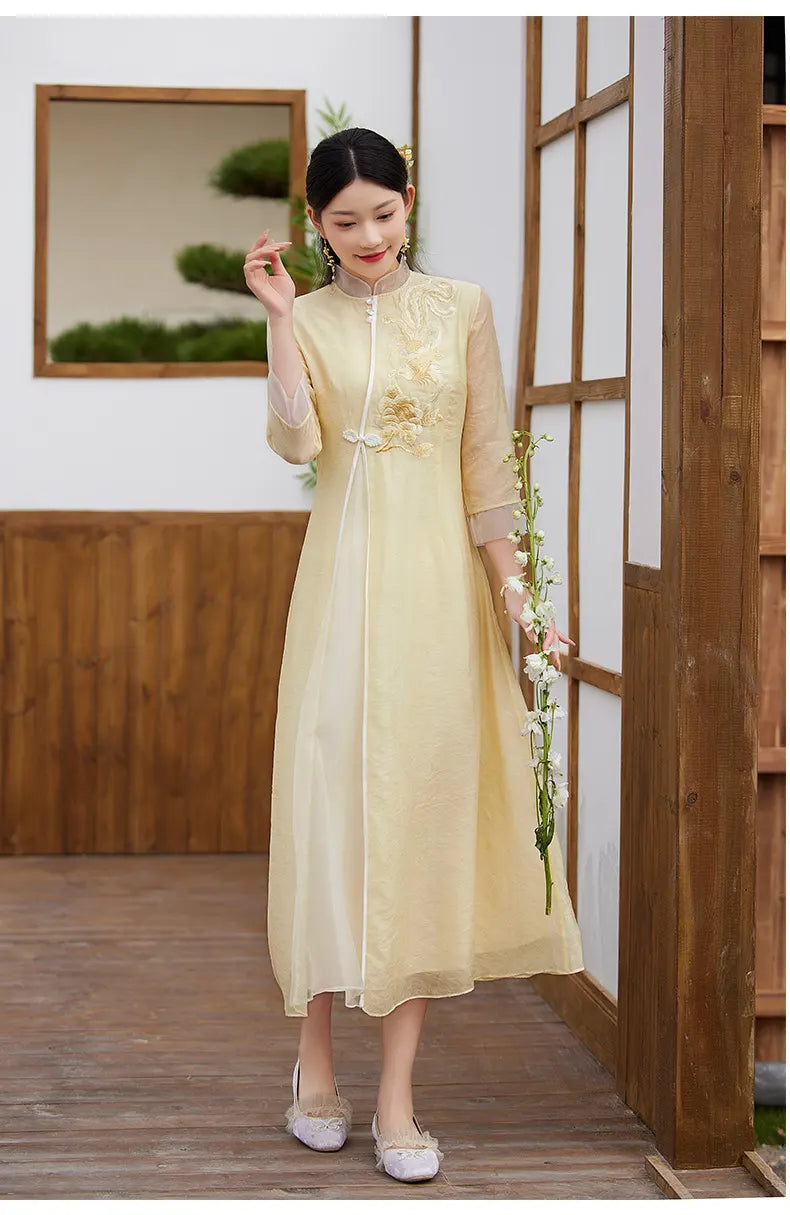 Woman in a Floral Embroidered Loose A line yellow Cheongsam Qipao Dress  holding flowers indoors.