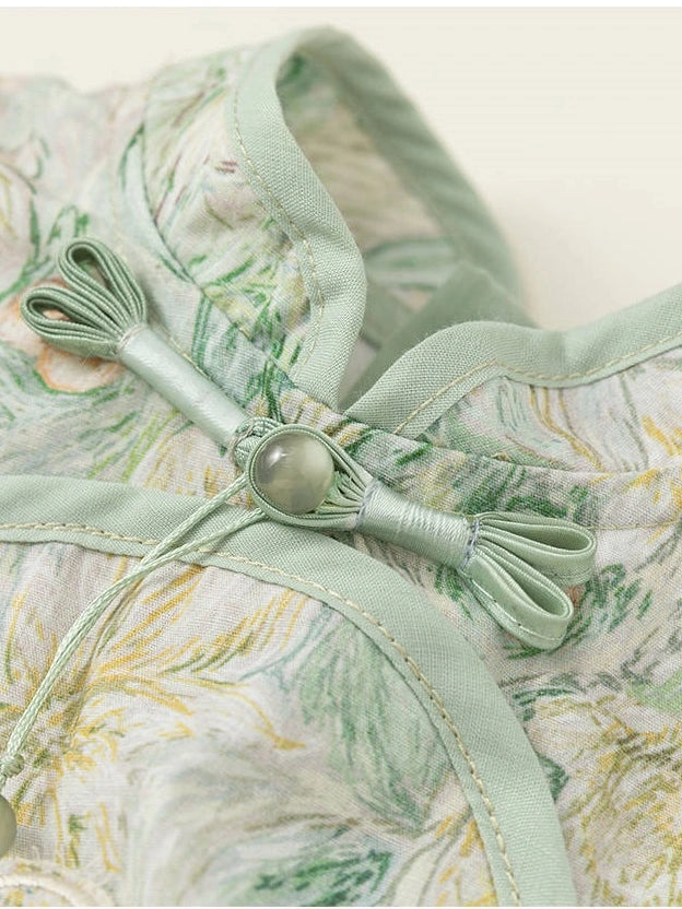 Close-up of a light sage green and white floral printed fabric garment featuring a traditional Chinese-style knot closure with a round bead.