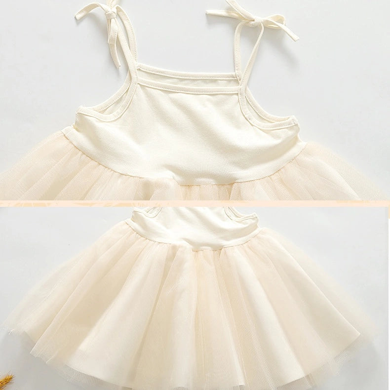 A baby girl's cream-colored two-piece outfit featuring a solid fabric camisole top with tie straps and a matching fluffy tulle tutu skirt, shown in a split-screen layout.