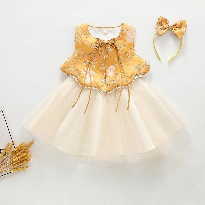 A baby girl's sleeveless  Golden Brocade Vest & Tulle Chinese Baby Princess Dress   with a yellow embroidered bodice and a cream tulle skirt, shown with a matching yellow bow headband on a white background.