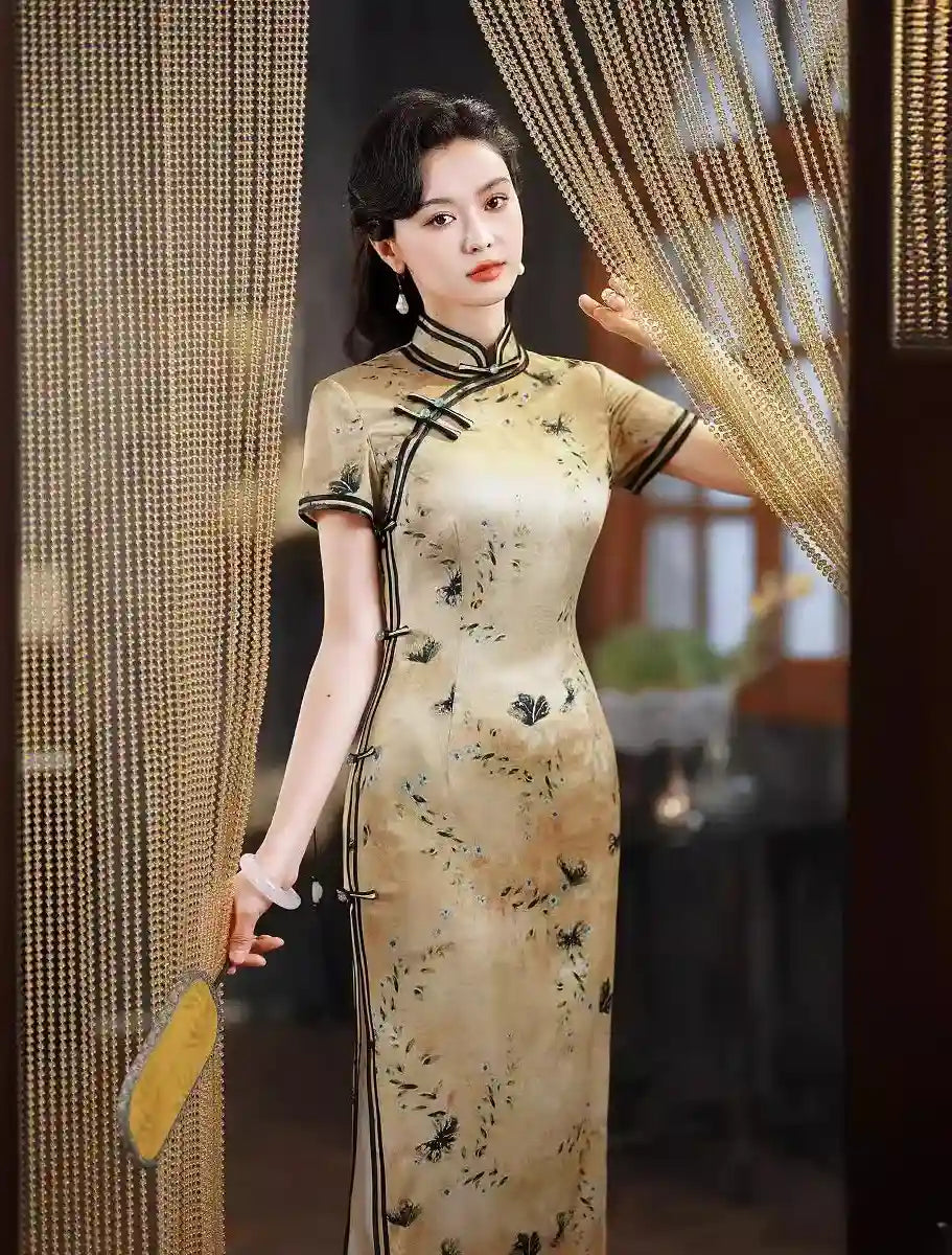 Woman in a traditional Gold Mulberry Silk Qipao Dress with Black Floral Print s standing in front of decorative curtains