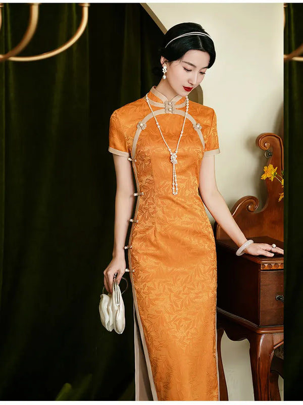 Woman in an Golden Orange Chinese Dress Qipao  with a necklace, standing next to a wooden chair.