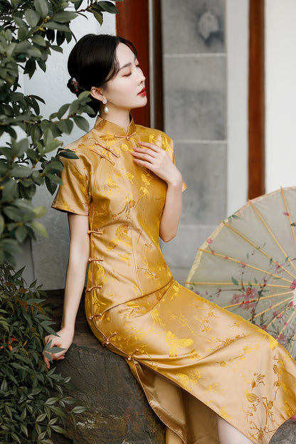 A chinese girl in gold silk cheongsam with  intricate floral and bird jacquard patterns sitting