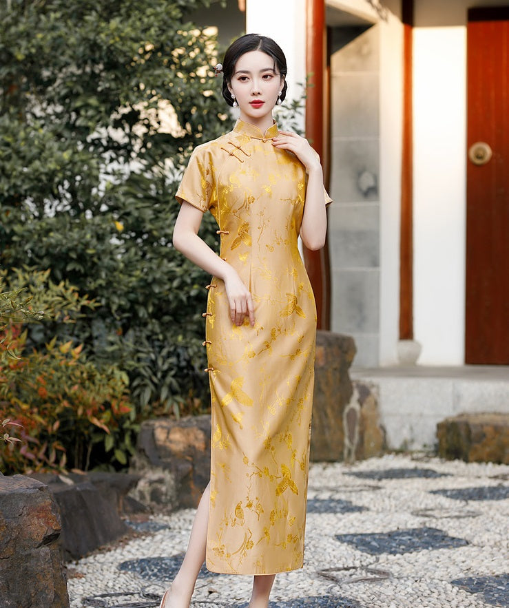 A chinese girl in gold silk qipao  with  intricate floral and bird jacquard patterns with umbrella on hand