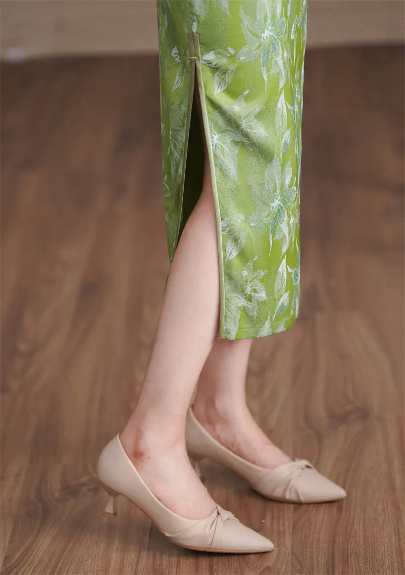 Person wearing green floral pants and beige shoes on a wooden floor