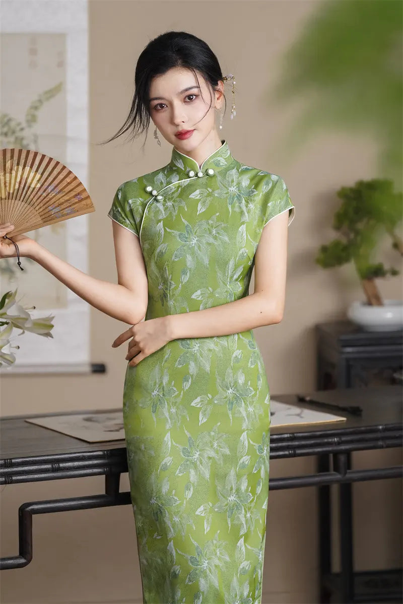 Woman in a Green Floral  Cap Sleeve Modern Qipao Cheongsam Dress  holding a fan in an indoor setting