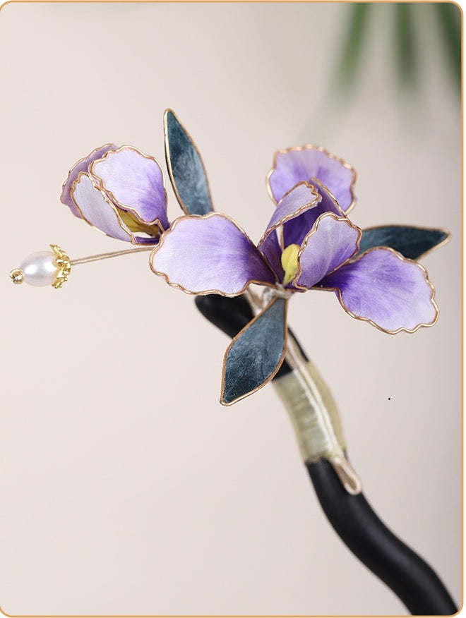 Purple flower-shaped hairpin with green leaves on a blurred background