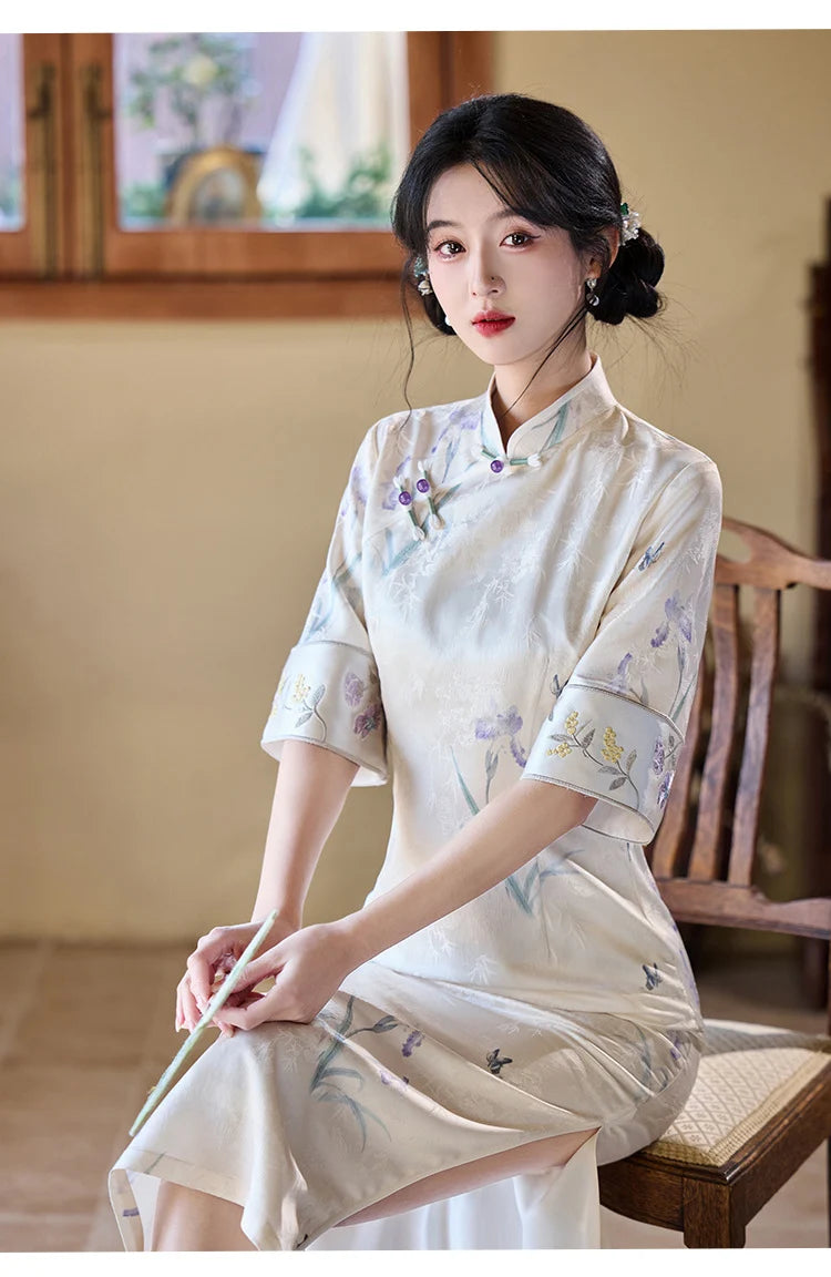 Woman in a traditional Chinese Ivory Floral Jacquard Qipao Dress with Embroidery outfit sitting on a wooden bench indoors.