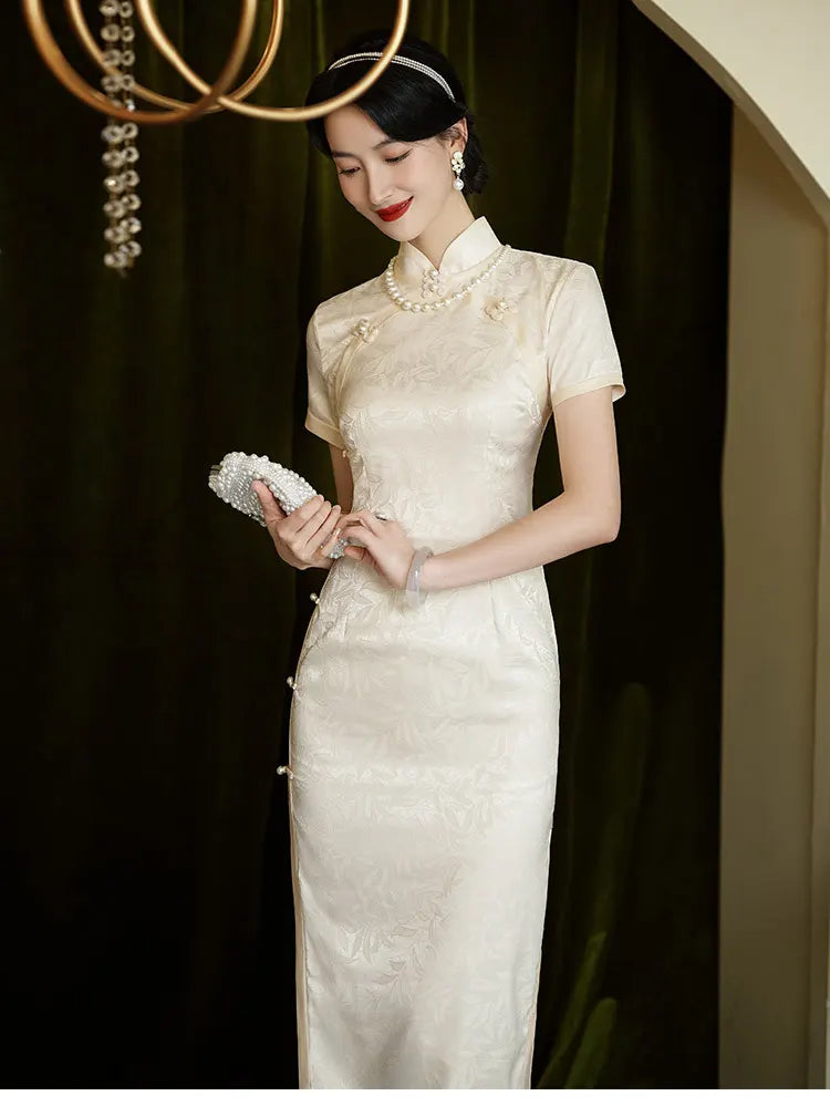 Woman in a Ivory White Floral Jacquard Short Sleeve traditional chinese  Qipao Dress holding a clutch against a dark background