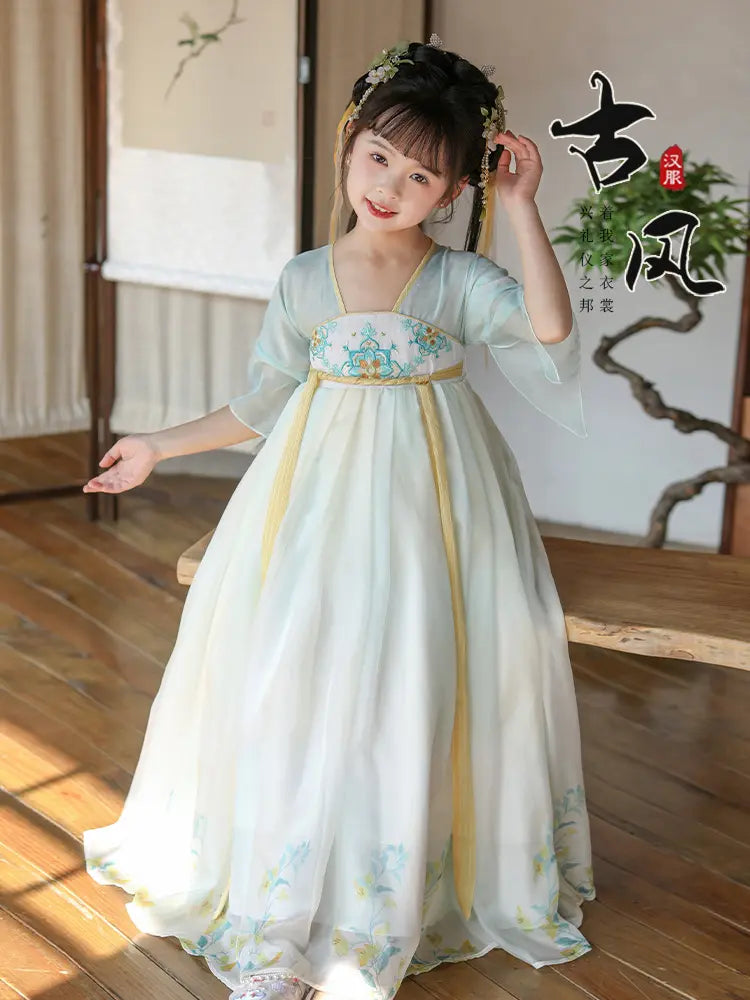 Child wearing a Light Blue Girls Chinese Tang Dynasty Style Fairytale Hanfu dress in a room with wooden floor and white wall.