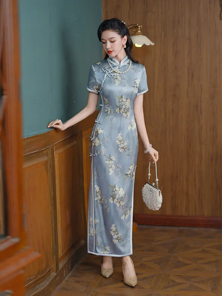 Woman in a Light Blue Mulberry Silk Floral Qipao Dress standing in a room with wooden paneling.