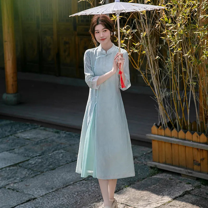 Woman in a Light Green Loose A Line Cheongsam Qipao Dress holding a traditional umbrella in a bamboo garden.