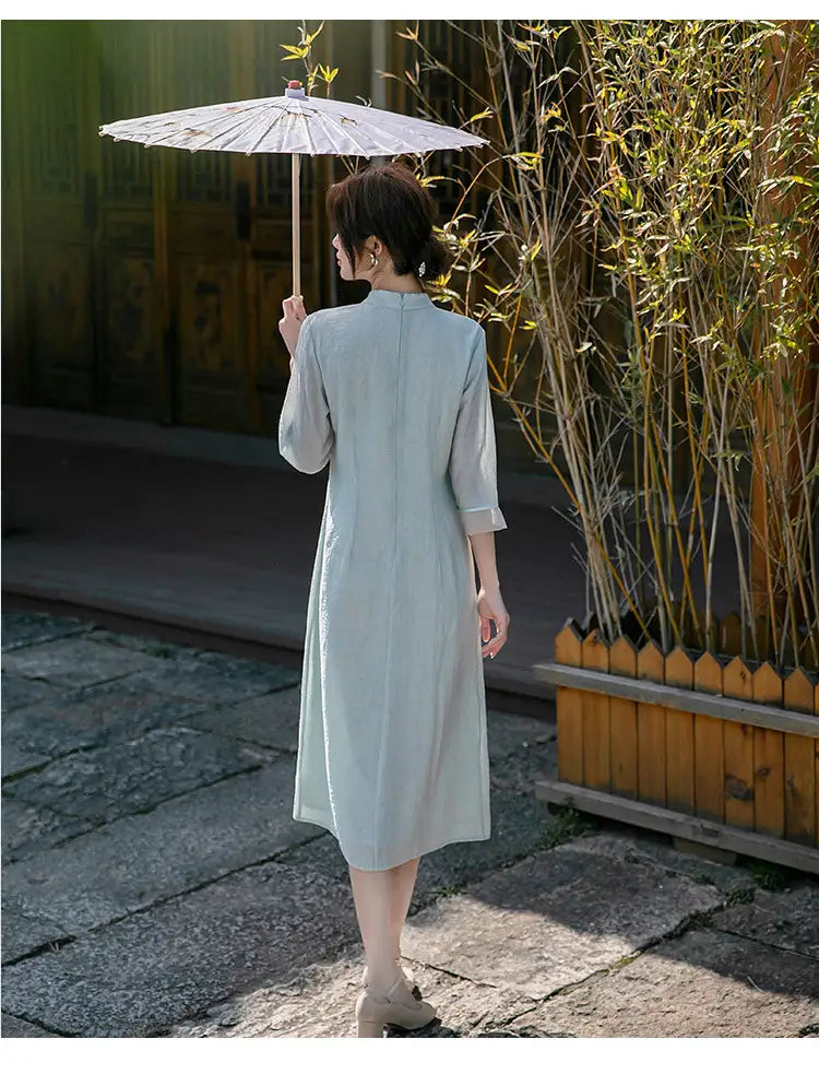 Person in a Light Green Loose A Line Cheongsam Qipao Dress  holding an umbrella in a garden setting