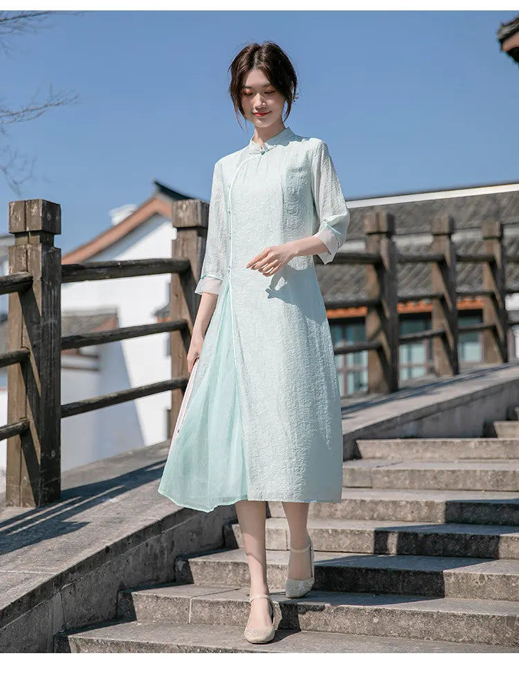 Woman in a Light Green Loose A Line Cheongsam Qipao Dress standing on stone steps with traditional architecture in the background