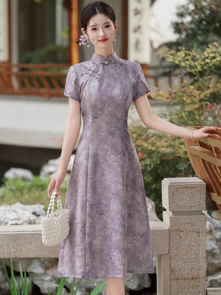 A woman wearing a short-sleeved Lilac Purple Floral Jacquard Modern A Line Qipao cheongsam dress with a subtle floral jacquard pattern, standing in a garden courtyard and holding a white pearl handbag.