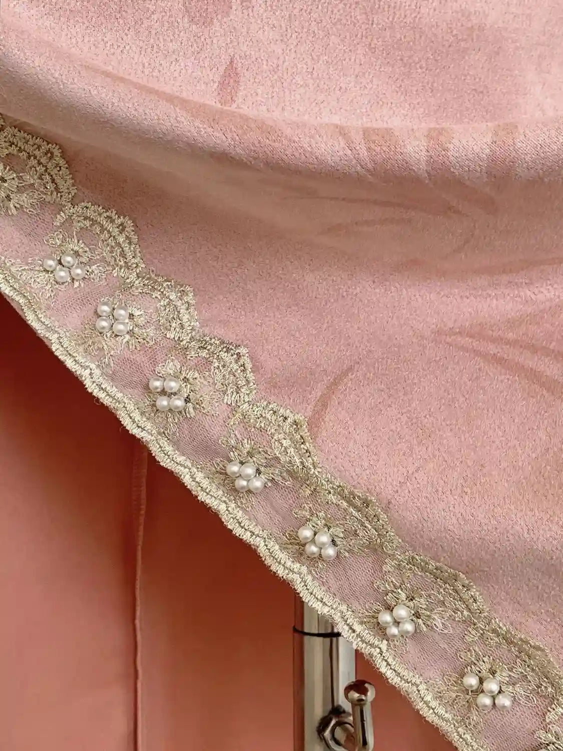 Close-up of pink fabric with decorative lace trim