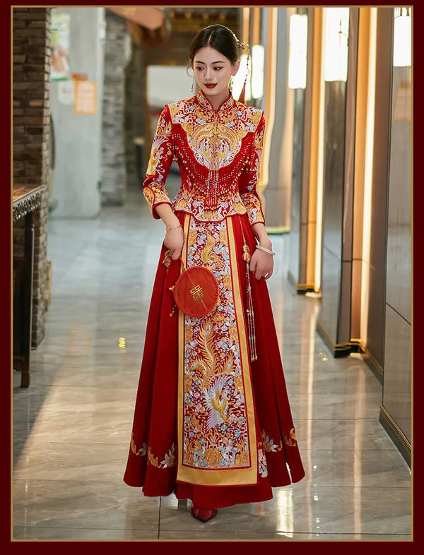Woman in a traditional red and gold Luxury Embroidered Dragon & Phoenix Bridal Wedding Qun Kwa Set   with intricate patterns in an indoor setting.