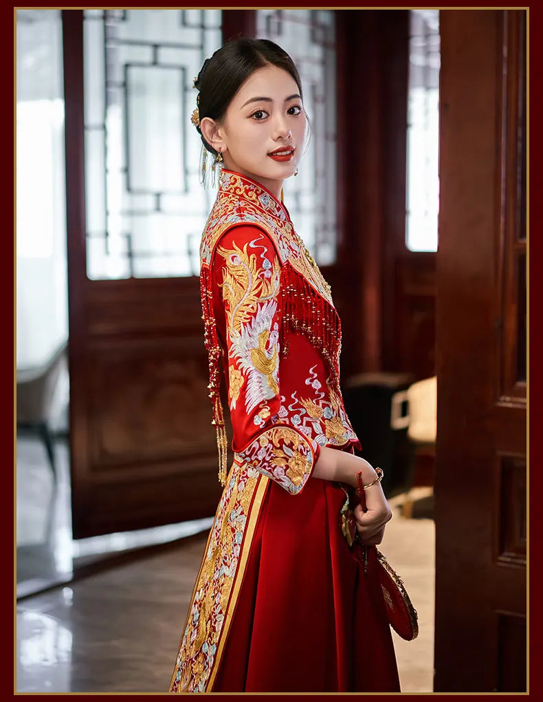 Woman in a traditional red and gold Luxury Embroidered Dragon & Phoenix Bridal Wedding Qun Kwa Set   with intricate patterns in an indoor setting.