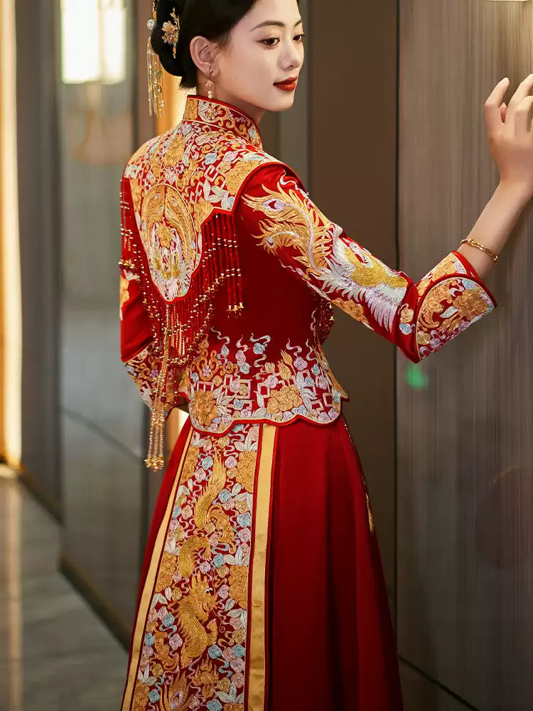 Woman wearing a traditional red and gold  Luxury Embroidered Dragon & Phoenix Bridal Wedding Qun Kwa dress with intricate patterns.