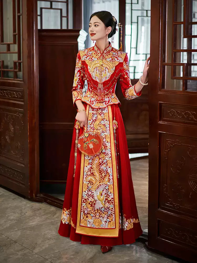 Woman in a traditional red and gold Chinese dress  Luxury Embroidered Dragon & Phoenix Bridal Wedding Qun Kwa Set  standing in a doorway.