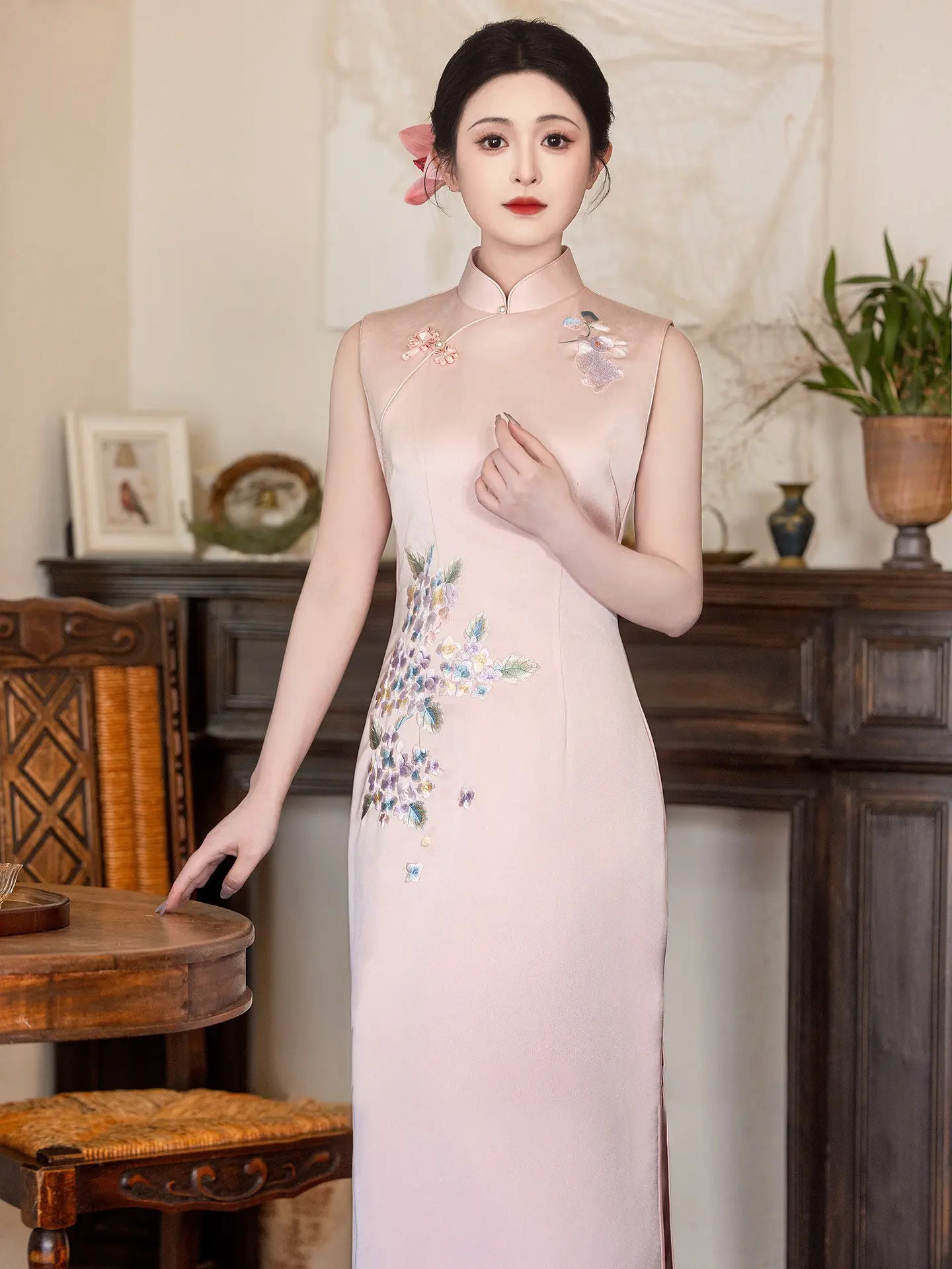 Woman in a traditional light pink Luxury Embroidered New Chinese Style Sleeveless Qipao Dress with floral embroidery in an elegant room.