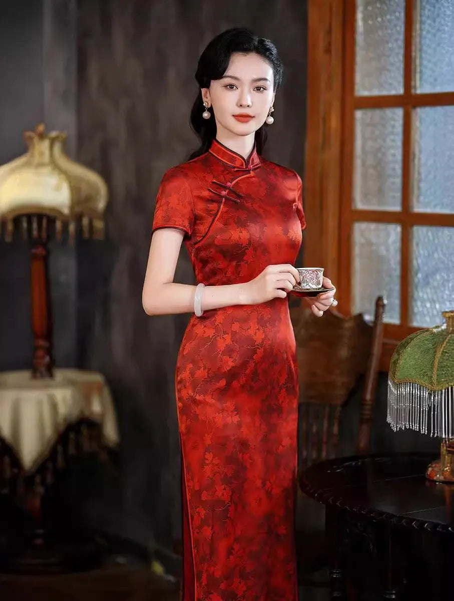 Woman in a red traditional Luxury Red Silk Qipao Dress with Maple Leaves Print holding a teacup in a vintage setting