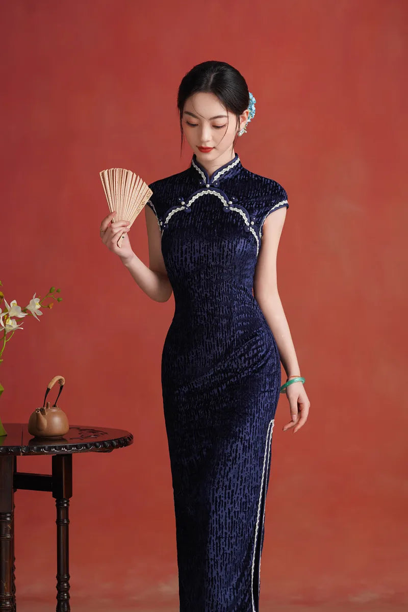 Woman in a Midnight Navy Blue Sleeveless Velvet Long traditional Qipao  Cheongsam dress holding a fan against a red background