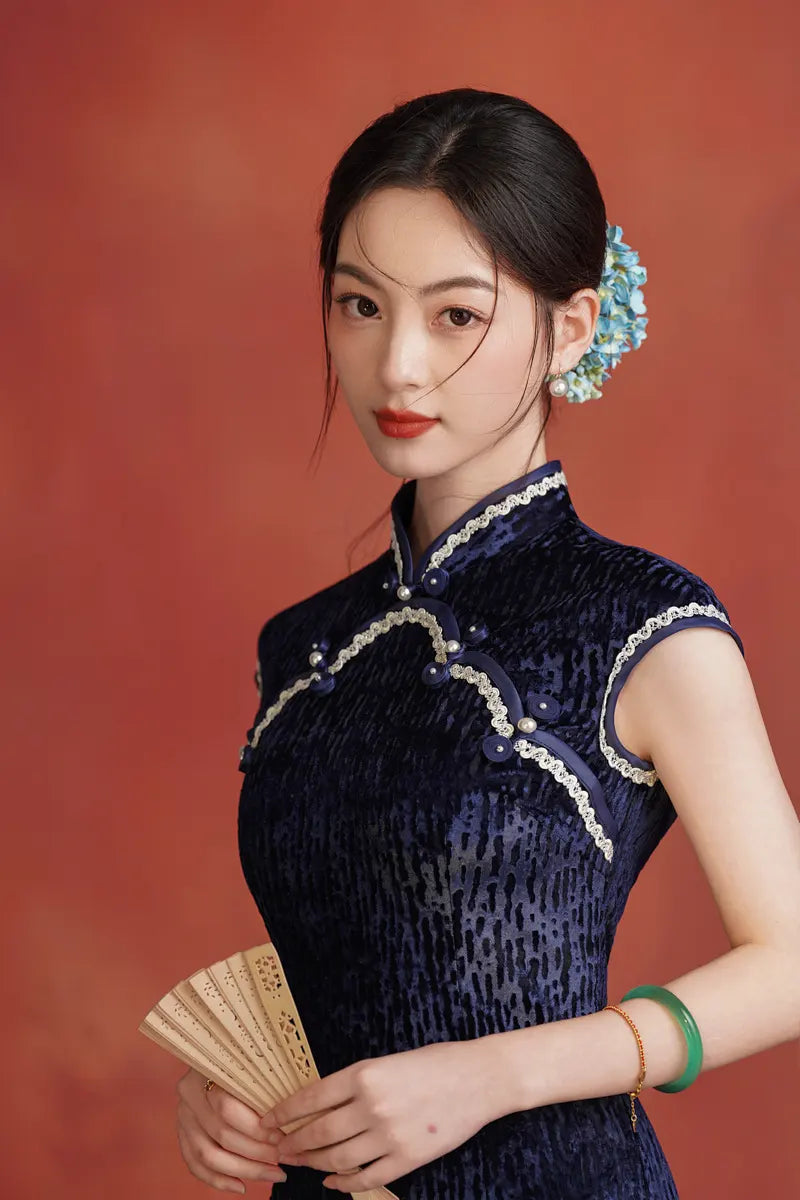 Woman in a Midnight Navy Blue Sleeveless Velvet Long  Qipao  traditional outfit with white trim against a red background