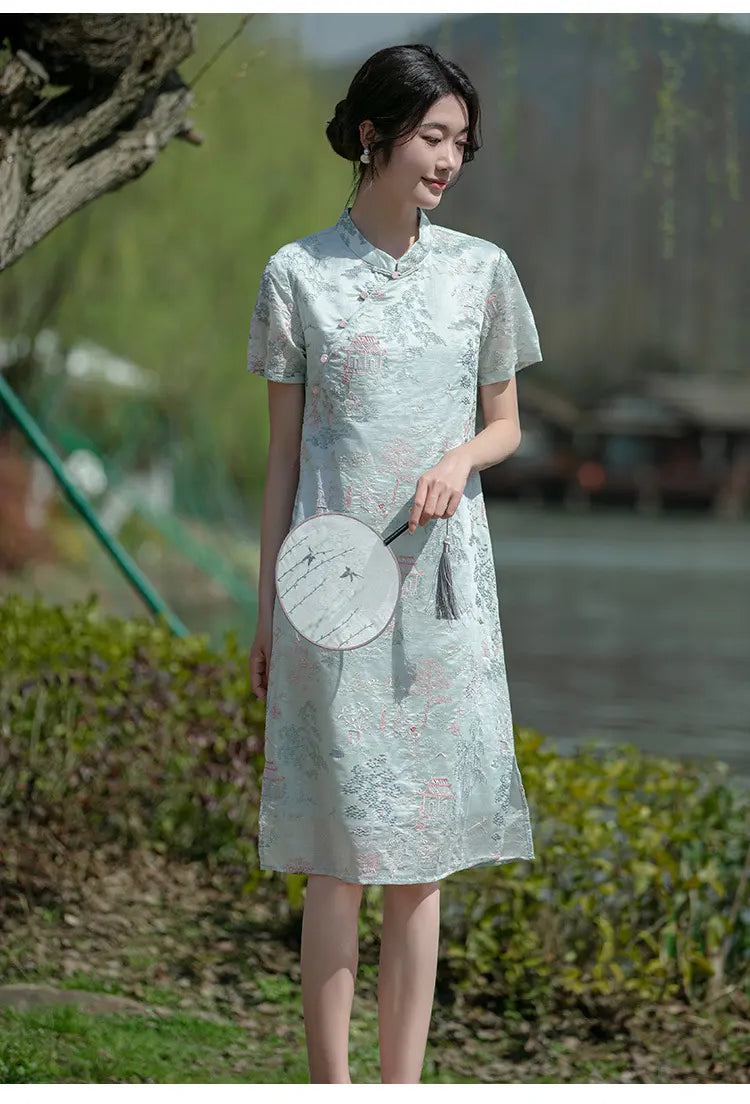 Woman in a lightMint Green Scenic Brocade Loose A Line Qipao Dress  holding a round fan outdoors