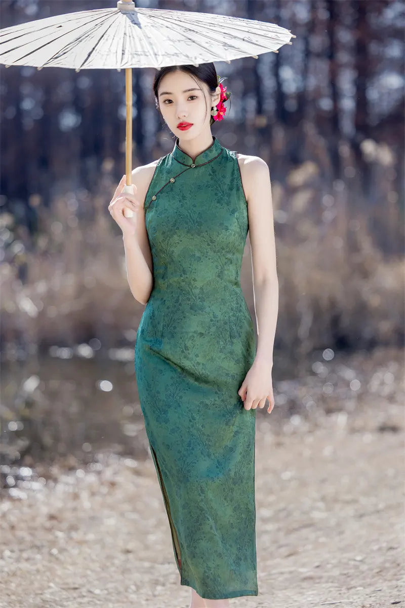 Woman in a green Modern Chinese Mandarin Dress Sleeveless Qipao  holding an umbrella with a blurred natural background