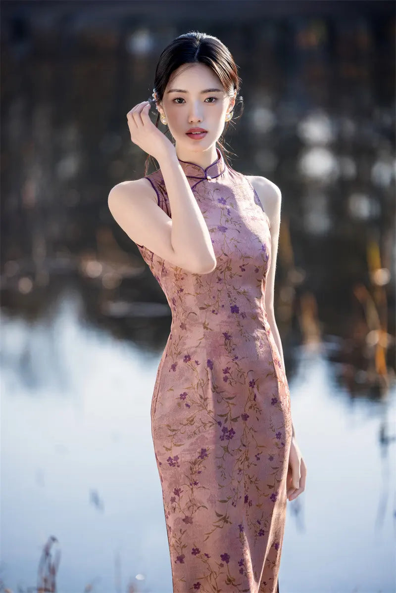 Woman in a floral pink Modern Chinese Mandarin Dress Sleeveless Qipao standing outdoors with a blurred natural background